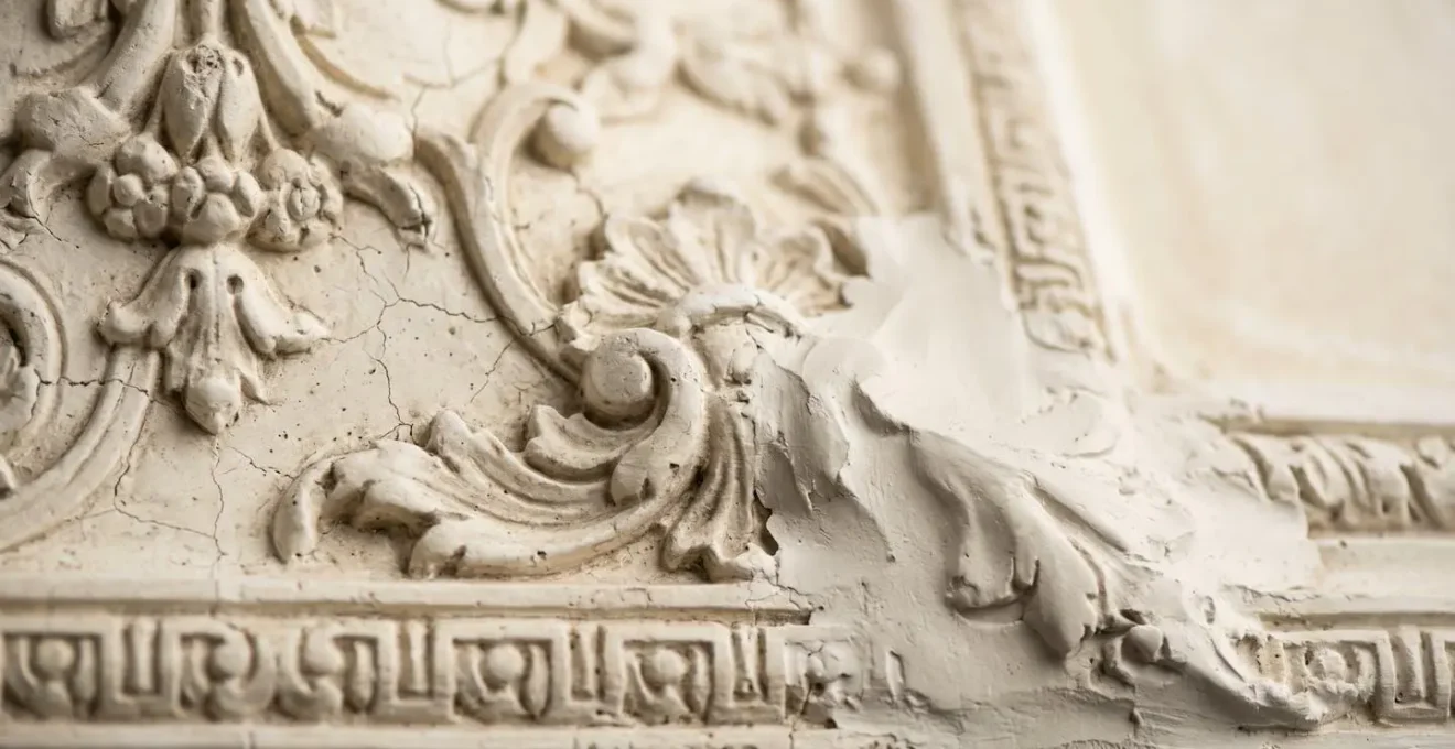 Detalle de restauración de molduras de escayola antiguas mostrando la técnica artesanal de reparación
